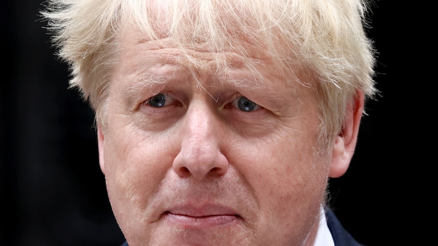A close up of Boris Johnson with tears in his eyes and the wind blowing his hair.
