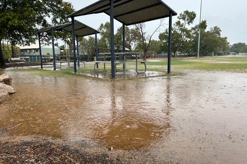 A sports ground is completely inundated with water as rain continues to fall. 