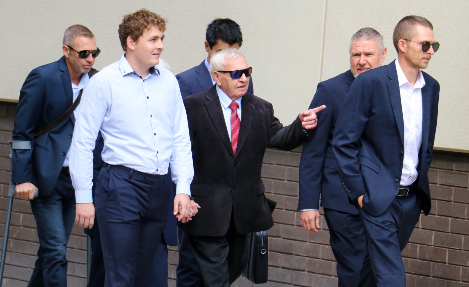 Barry Cable aponta enquanto está cercado por apoiadores enquanto caminha para o tribunal