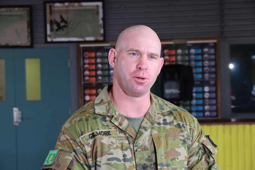 A man with no hair wearing an ADF uniform speaking at a press conference. 
