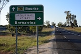 A road sign indicating the way to Bourke and Brewarrina on the edge of a country highway.