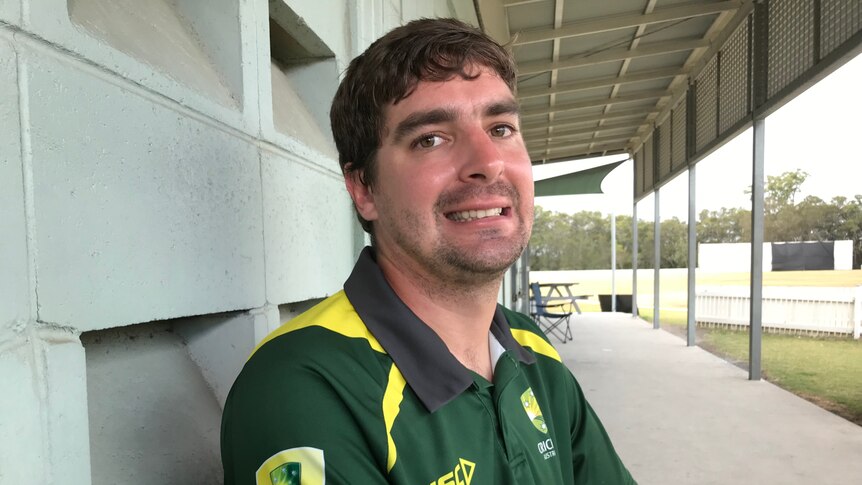 A man wearing Australian cricket gear smiling for the camera.