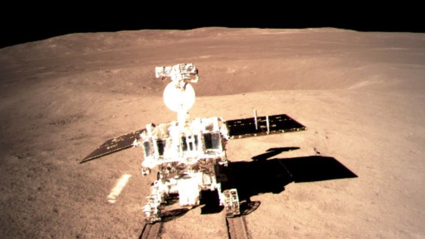Yutu-2 rover is seen rolling out onto the surface of the Moon, which appears brown, with a black sky above.