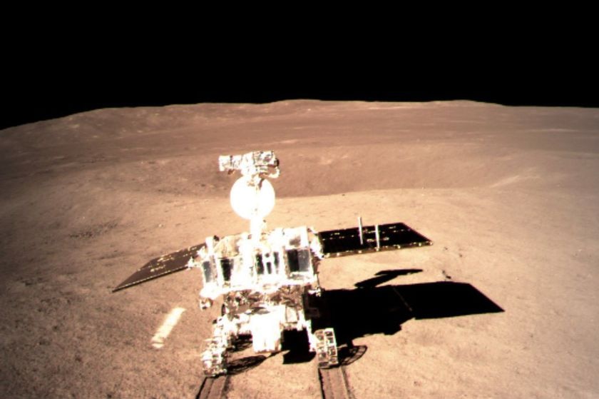 Yutu-2 rover is seen rolling out onto the surface of the Moon, which appears brown, with a black sky above.