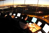 Air traffic controllers in the tower at Sydney airport with the sun low in the sky