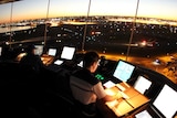 Air traffic controllers in the tower at Sydney airport with the sun low in the sky