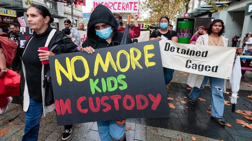 Protestors march the streets holding signs during a rally in Perth