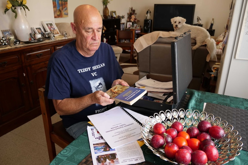 Teddy Sheean's nephew, Garry Ivory, looks at materials about his uncle, 2019