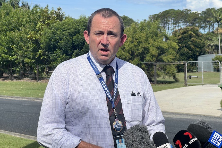 An image of a police officer adressing media on a suburban street in Burpengary