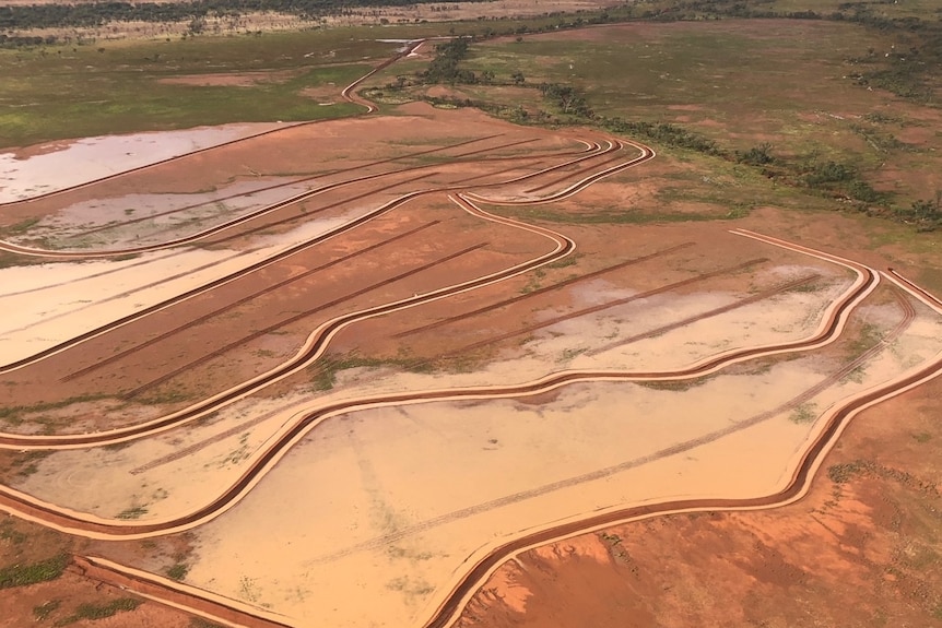 An aerial shot of banks of soil holding water in a floodplain on Picarilli station.