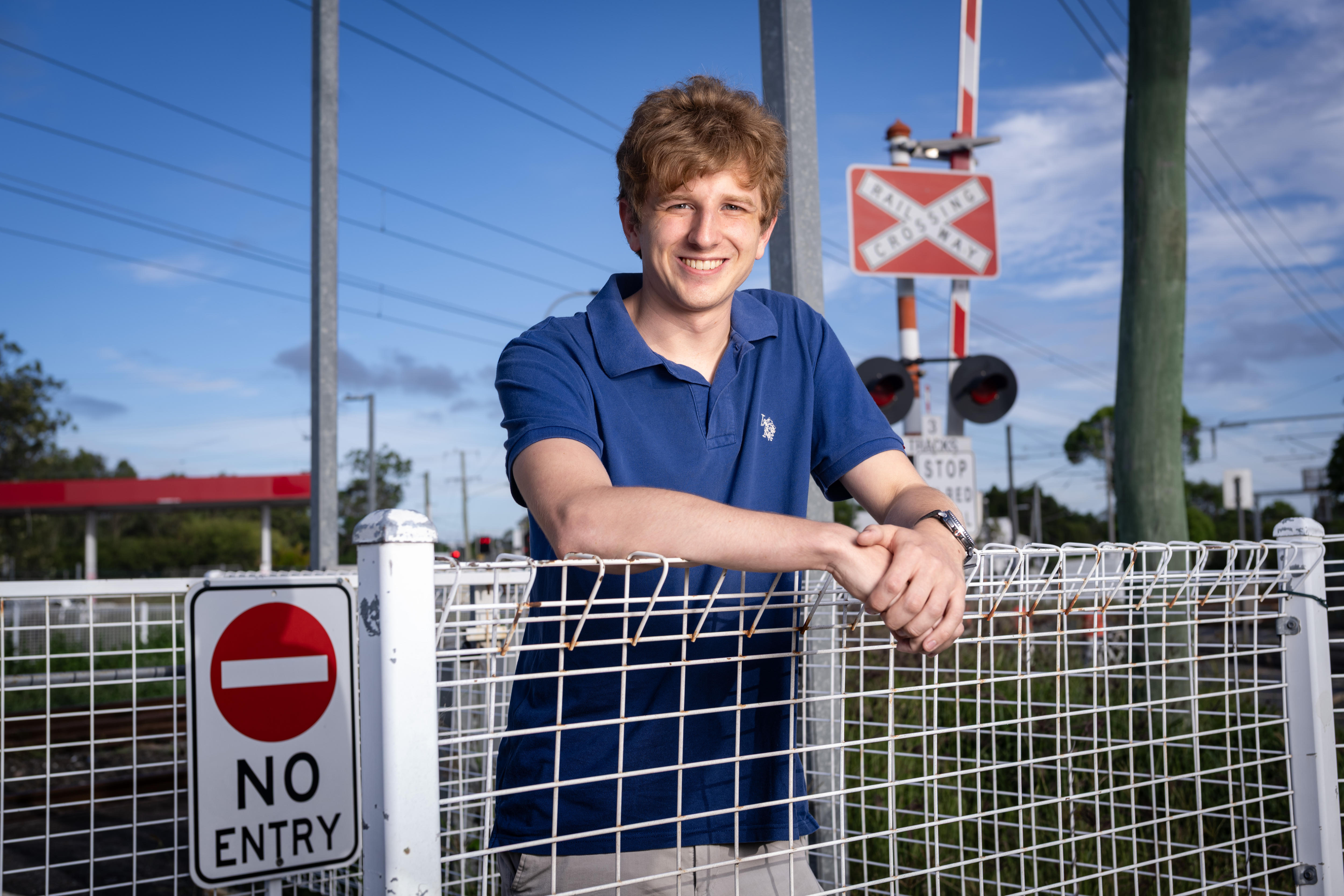 Un hombre junto a un cruce de ferrocarril