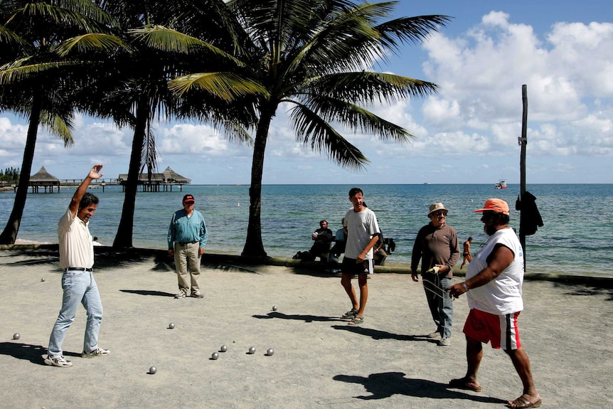 Locals on the beach in Noumea, New Caledonia, play the traditional ball game "petanque".