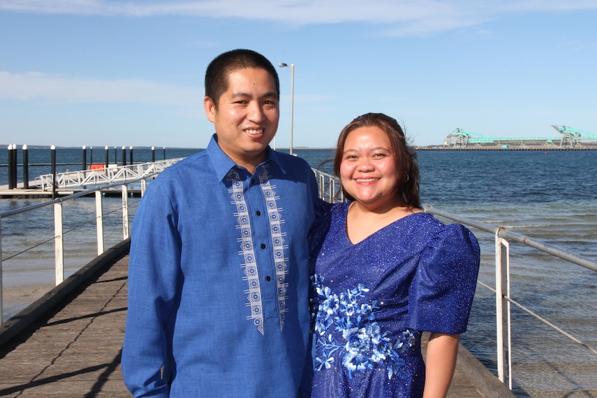 a Filipino man and woman wear culture blue clothes on a SA jetty.