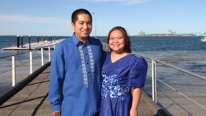 a Filipino man and woman wear culture blue clothes on a SA jetty.