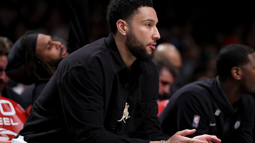 Ben Simmons sits and claps his hands