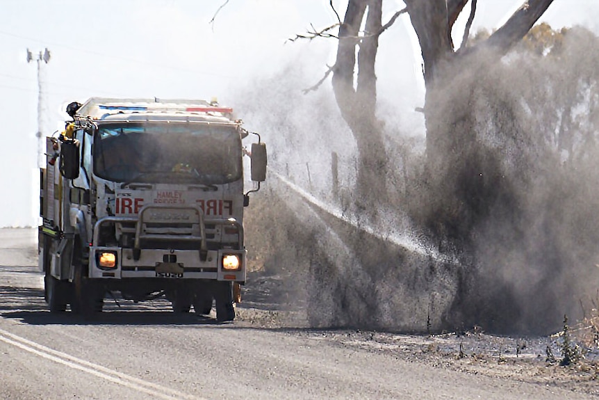 Fire crew battling a flare up on a roadside