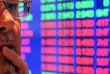 Investor at ASX watches stock price monitors