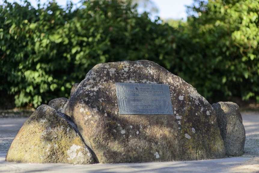 Edward George Honey memorial plaque in Melbourne, surrounded by trees in the background.