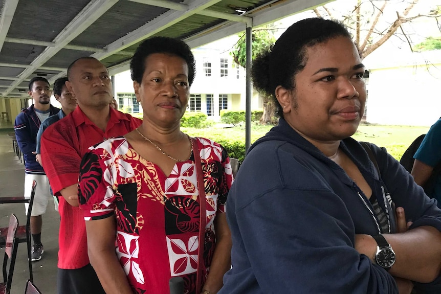 People standing in line at a polling station.