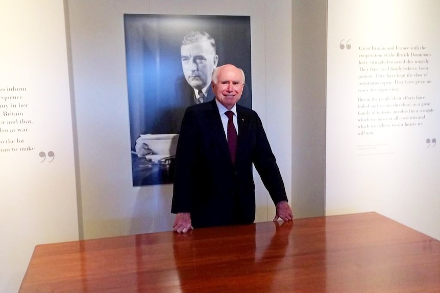 John Howard at desk in the Menzies exhibition
