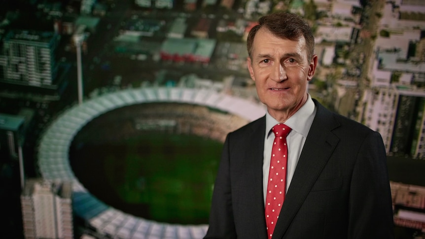 graham quirk in front of an aerial image of a stadium