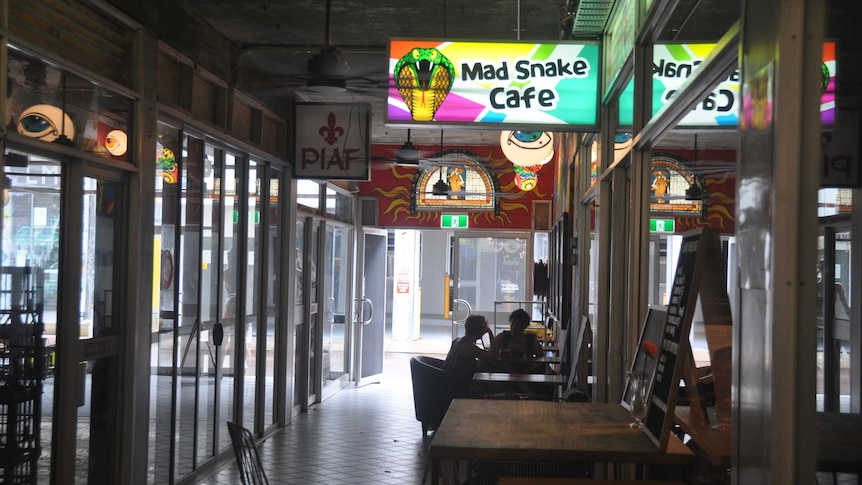 An arcade with people drinking coffee.