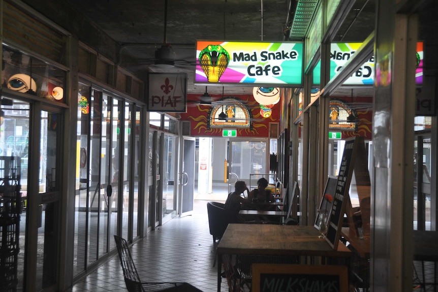 An arcade with people drinking coffee.