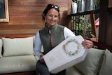 Business owner Zoe Ednie-Brown sits with one of her biodegradable coffins.