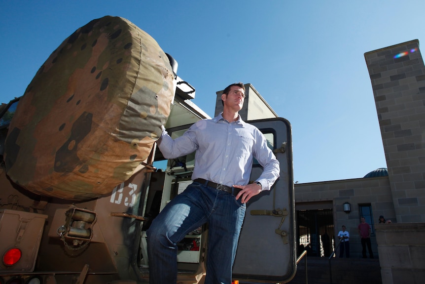 Ben Roberts-Smith VC poses for photographs at a Bushmaster Infantry Mobility Vehicle in 2013