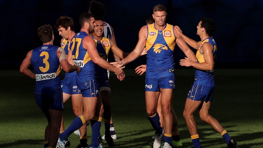 Nathan Vardy stands surrounded by West Coast Eagles teammates during an AFL game against Fremantle.