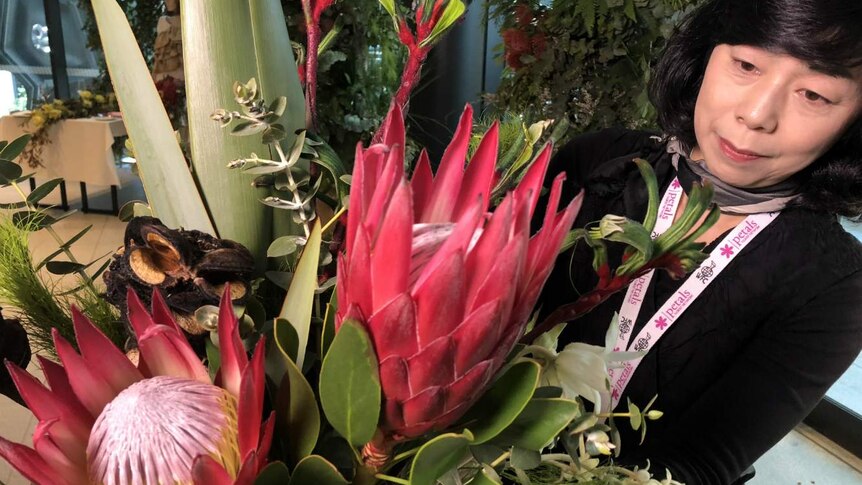 Japanese flower importer Midori Kitahari admires a bouquet of proteas.