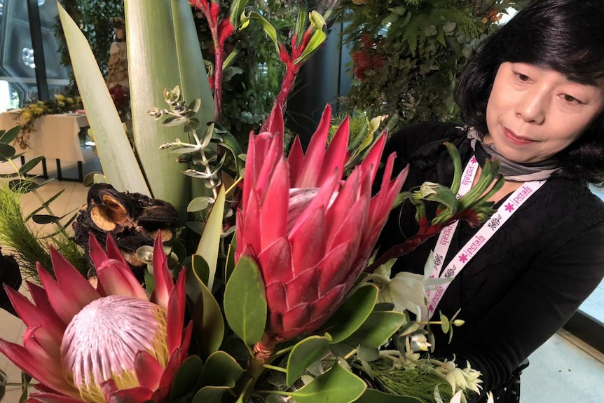 Japanese flower importer Midori Kitahari admires a bouquet of proteas.