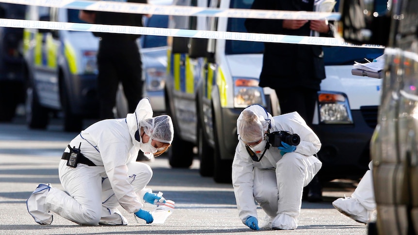 Forensic officers collect evidence at the scene where two female police officers were killed.