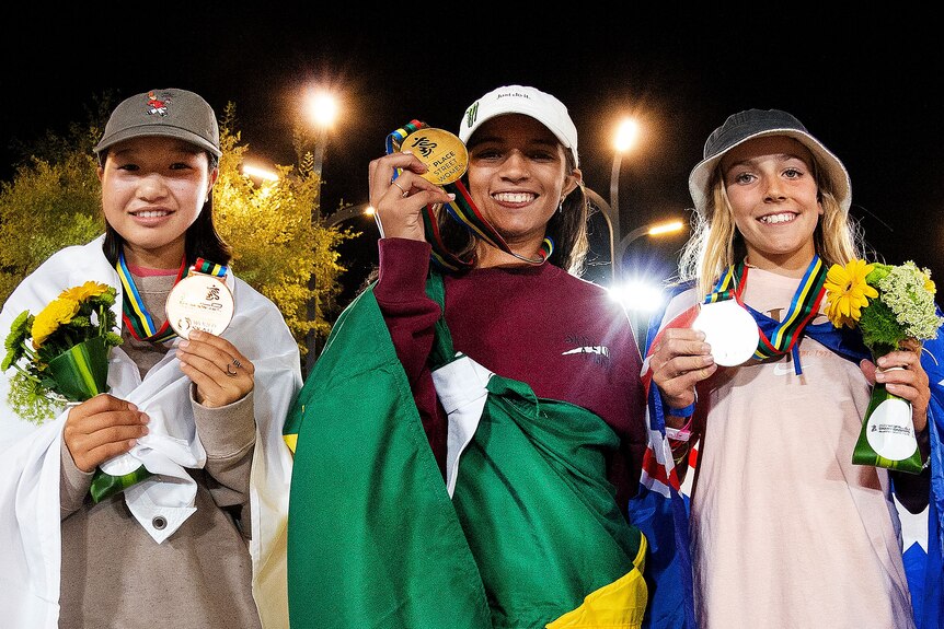 three girls holding medals