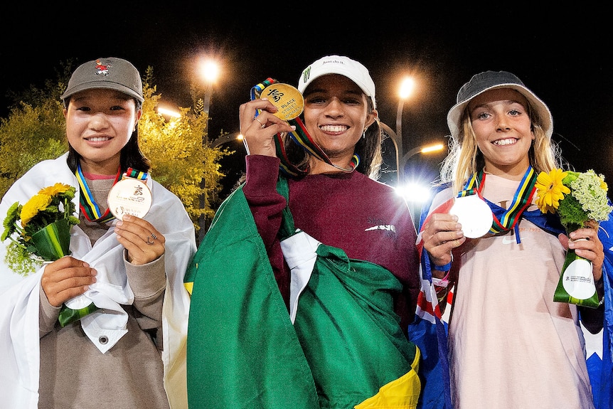 three girls holding medals