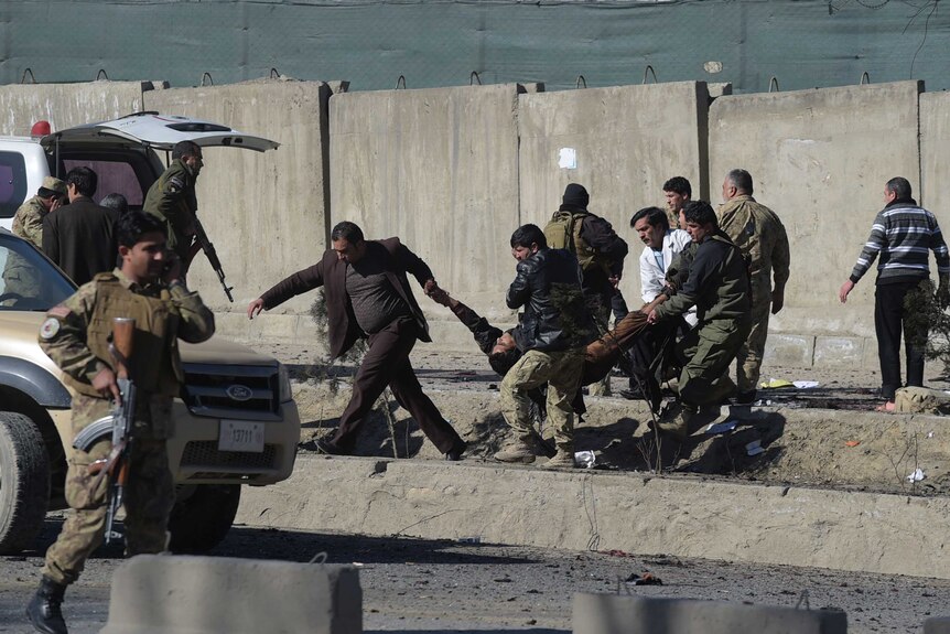 Afghan security forces carry a victim of a suicide attack in Kabul