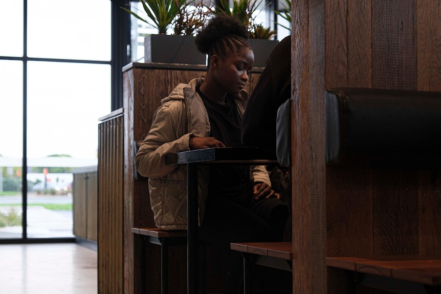 Teenage girl listens to instructions from a manager in a restaurant