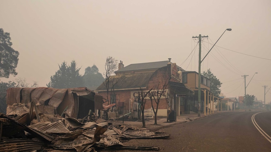 Firefighters inspect fire damage in Cobargo on Wednesday. January 1.