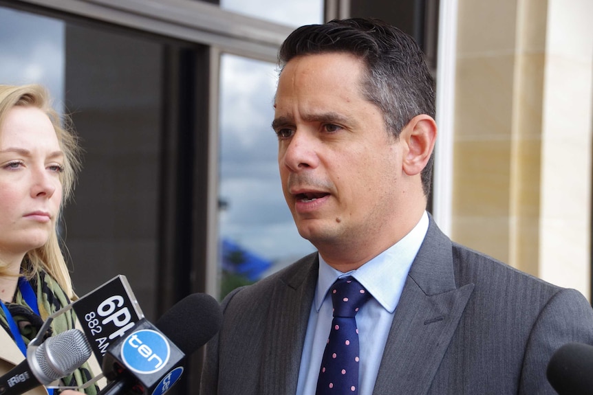 Ben Wyatt outside Parliament House. A reporter from 6PR looks at him while he talks.