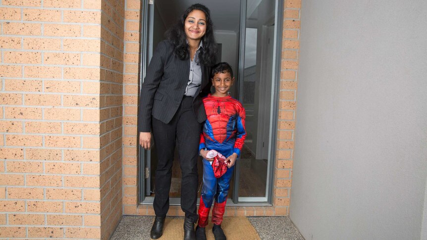 Single mother Paurnami Jitesh and her son Dev out the front of their home.