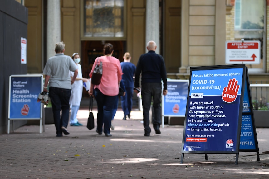 people walking towards the entrance of a hospital