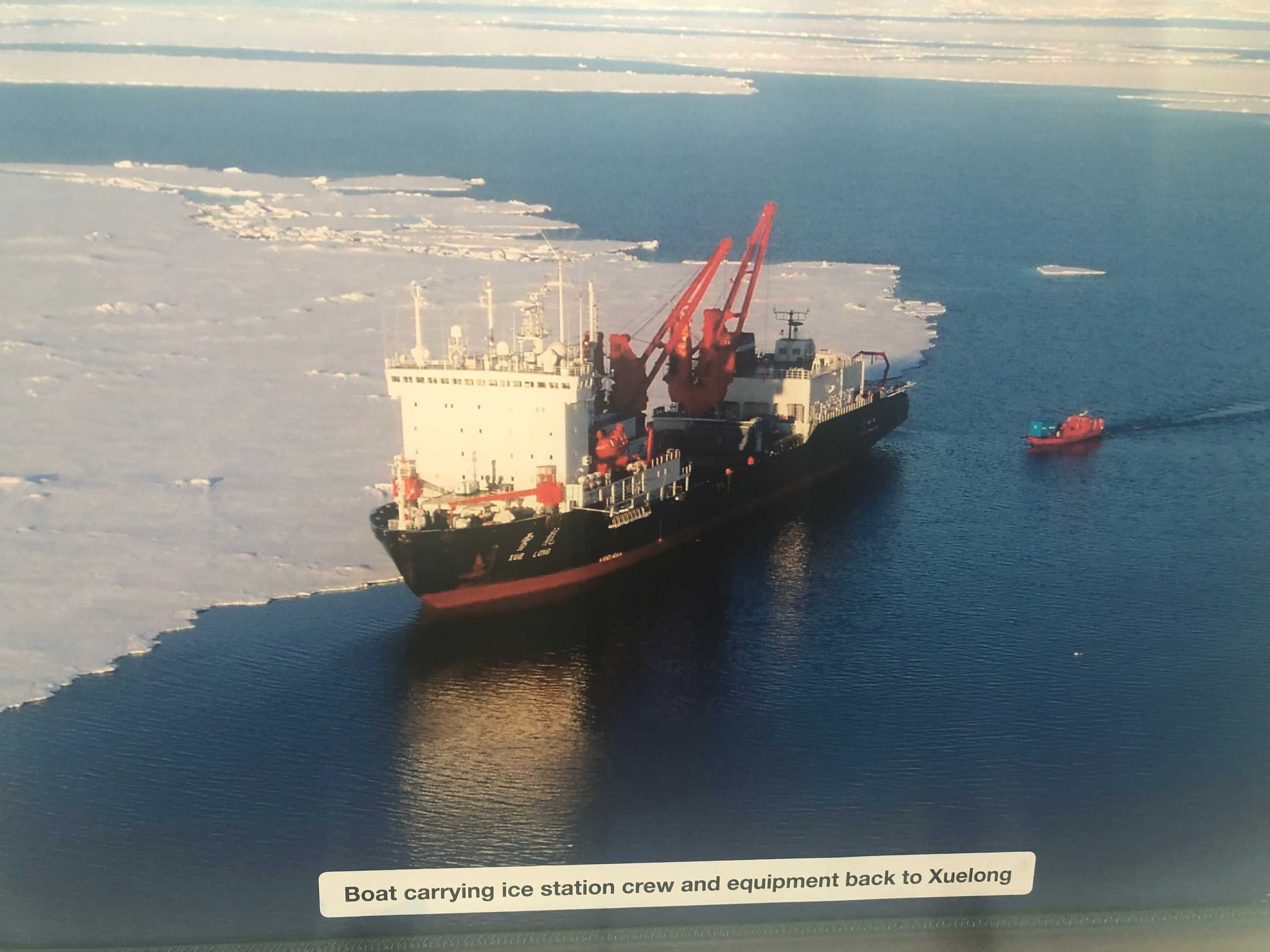 An icebreaker ship near a sheet of ice on the ocean.