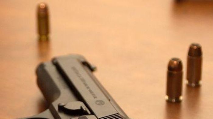 A hand gun lying on a table with bullets around it, September 2007. Good gun, weapon generic.