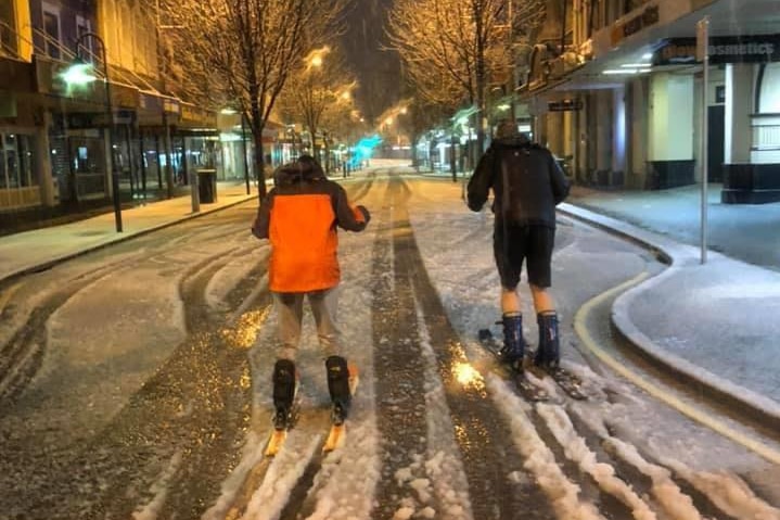 Two people ski through snow on Launceston street.