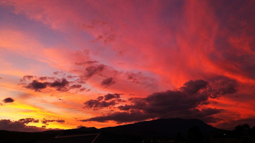 pink and orange clouds over silhouetted mountain