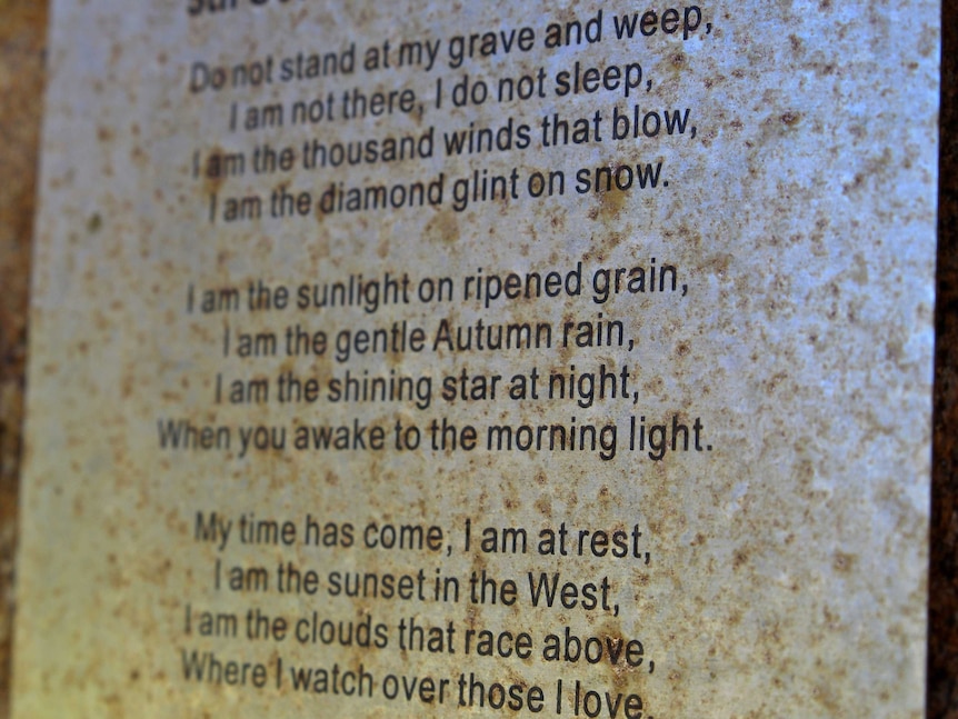 Lines of verse from Mary Elizabeth Frye: 'do not stand at my grave and weep' on a metal plaque.