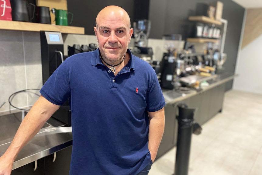 Phillip Di Bella leans on a bench at his café and commercial coffee production facility.