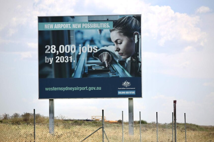 A sign by the road says "28,000 jobs by 2031"