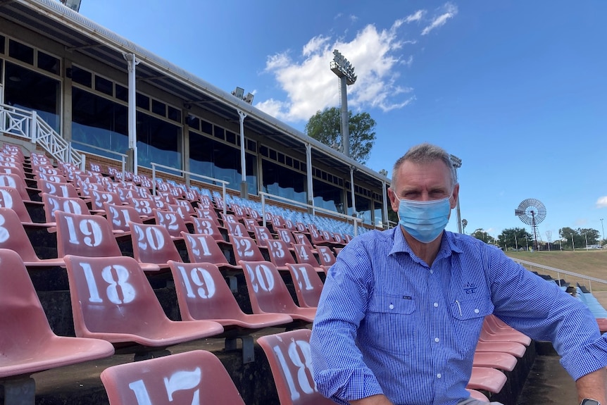 Damon Phillips, the CEO of RASQ sits on numbered seats in the grandstand at the Toowoomba showgrounds