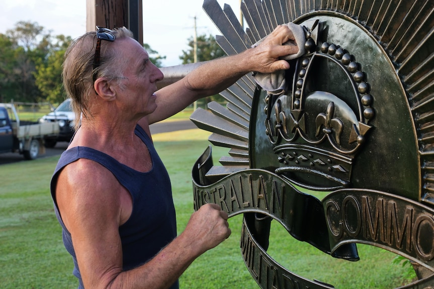 man polishes war memorial